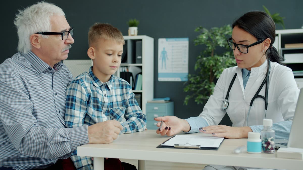 a young boy visiting a medical practitioner accompanied by his grand father